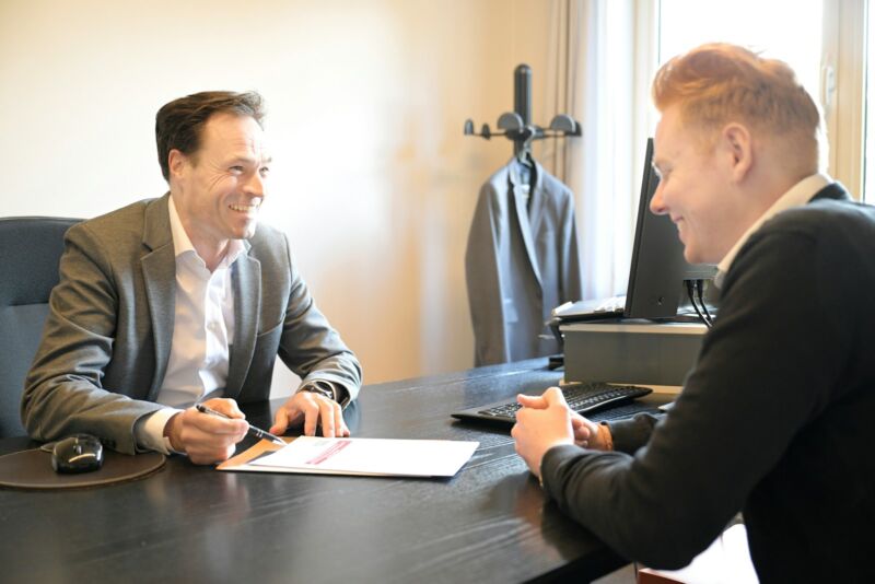 Two men going over documents at an office desk