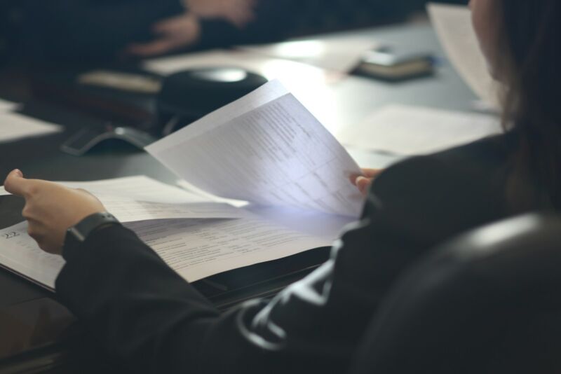 A woman carefully reading a printed document