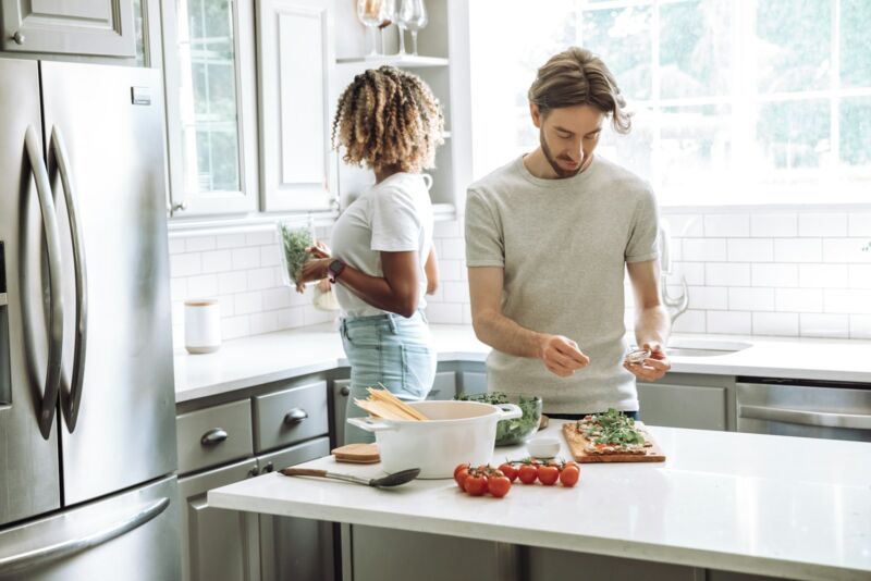A parent and child cooking together in the kitchen