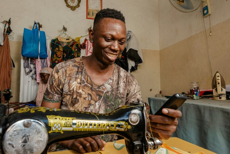 A tailor working at a sewing machine in his shop