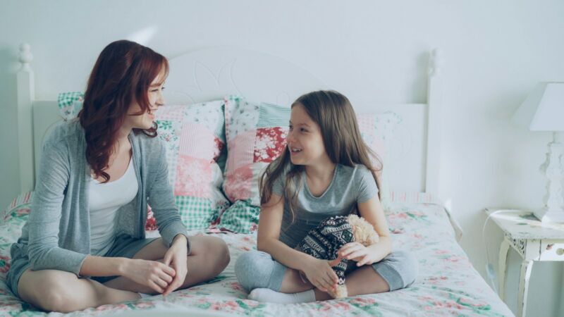 A mother and young daughter talking gently