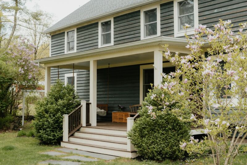 A blue house with a welcoming front porch