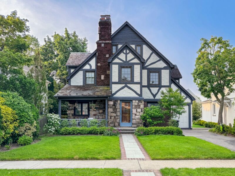 A stone and timber house with a green front yard