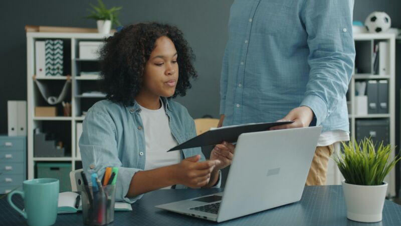 Two people reviewing documents together at a desk