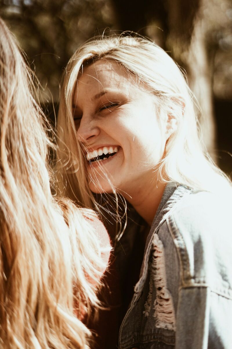 A woman smiling outdoors in daylight