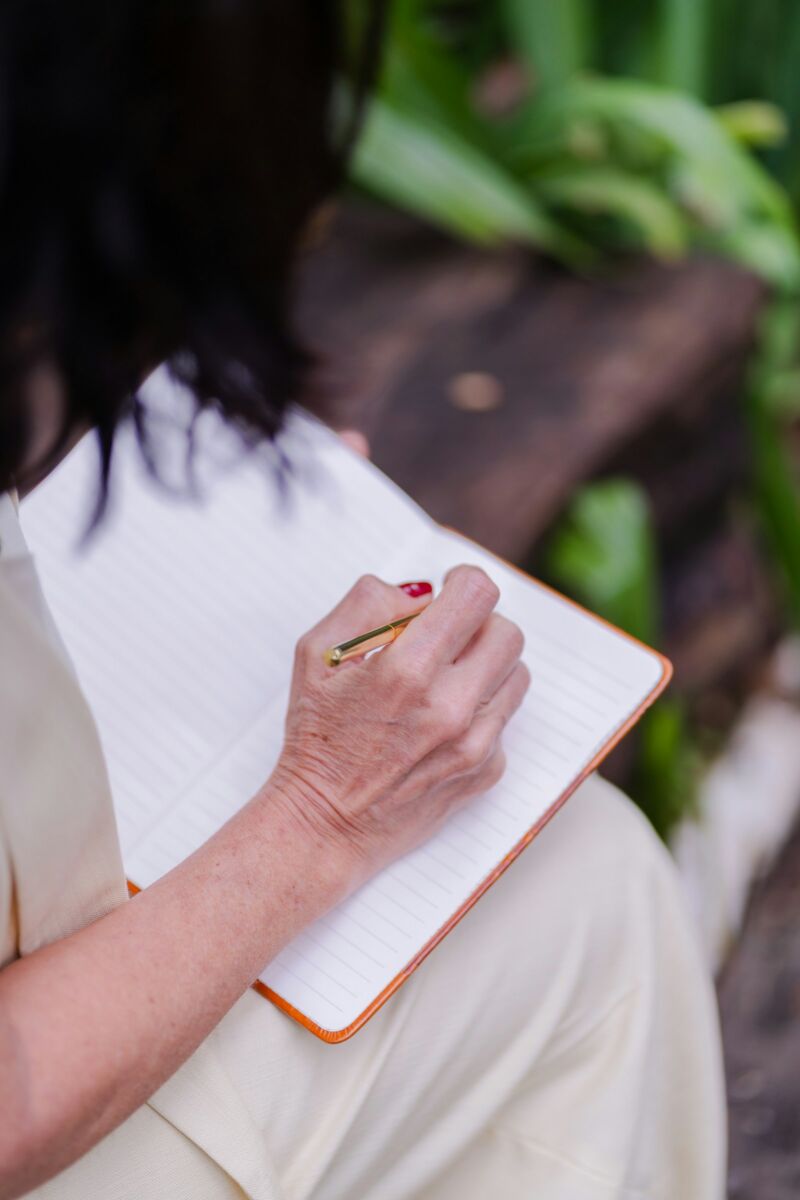 A woman writing in a journal outdoors