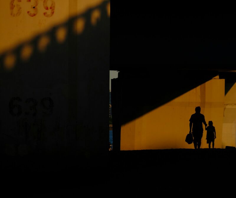 A parent and child walking together at sunset