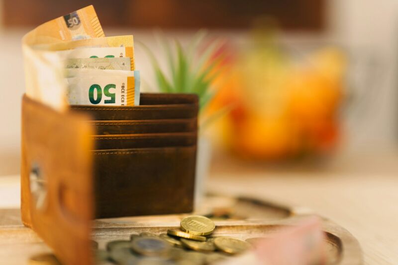 A wallet with banknotes and coins on a table